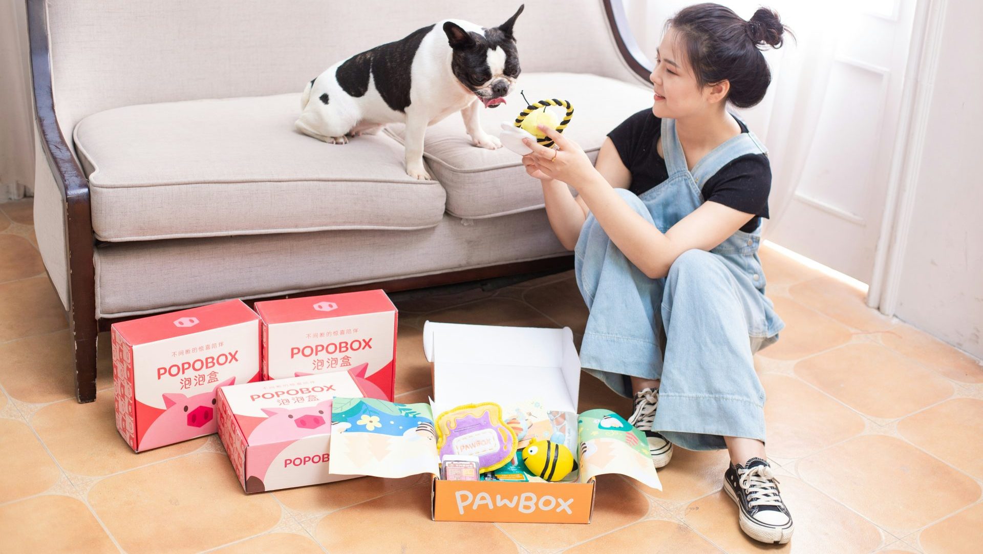 Woman and dog with treats and pawbox products.